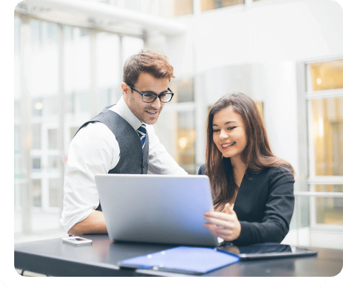 A man and woman looking at a laptop.