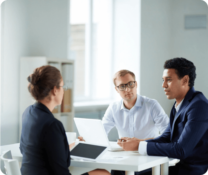 Three people sitting at a table with papers